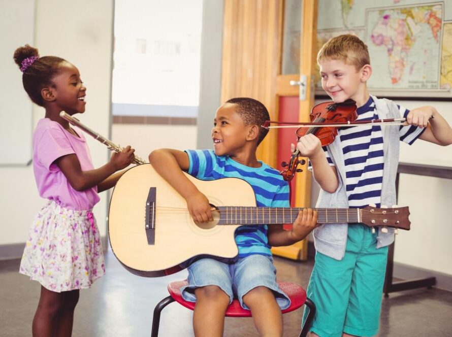 smiling-kids-playing-guitar-violin-flute-in-classroom